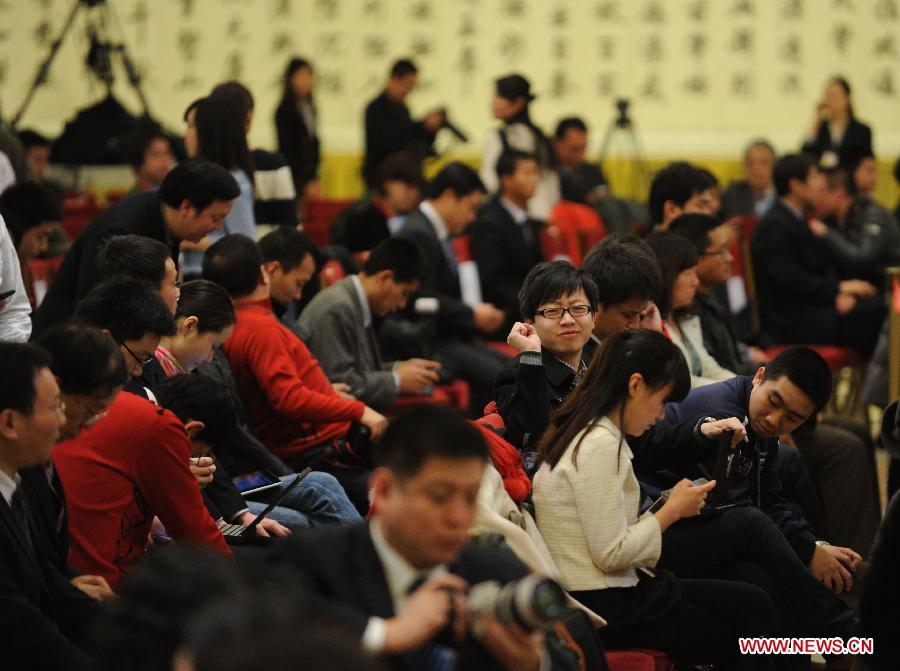 Journalists wait for a press conference which Chinese Premier Wen Jiabao will attend after the closing meeting of the Fifth Session of the 11th National People's Congress (NPC) at the Great Hall of the People in Beijing, capital of China, March 14, 2012.