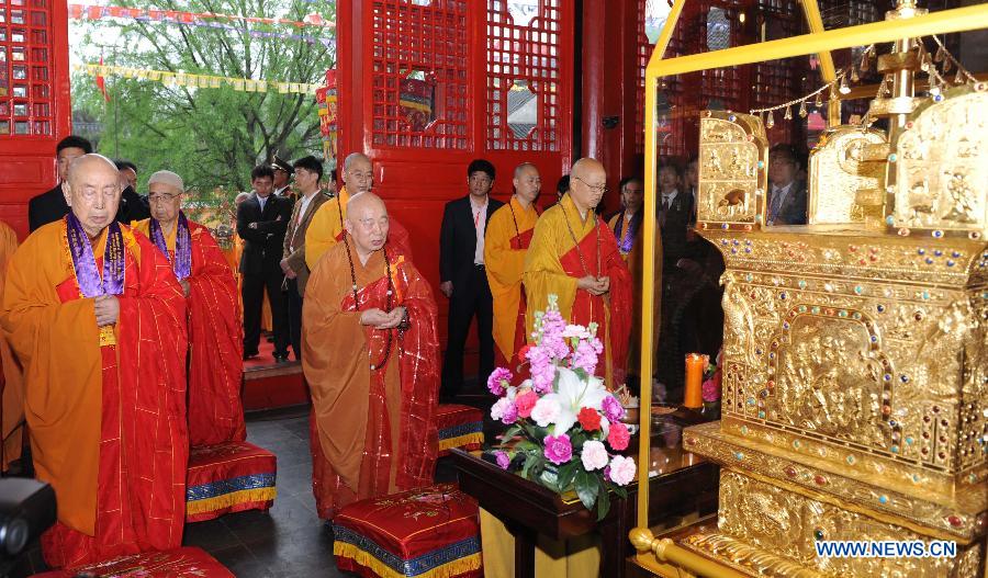 Master Chuanyin (C) from the Buddhist Association of China and Ven. Kok-kwong (L) of the Hong Kong Buddhist Association attend a moving out ceremonoy at Qixia Temple in Nanjing, capital of east China&apos;s Jiangsu Province, April 25, 2012. 