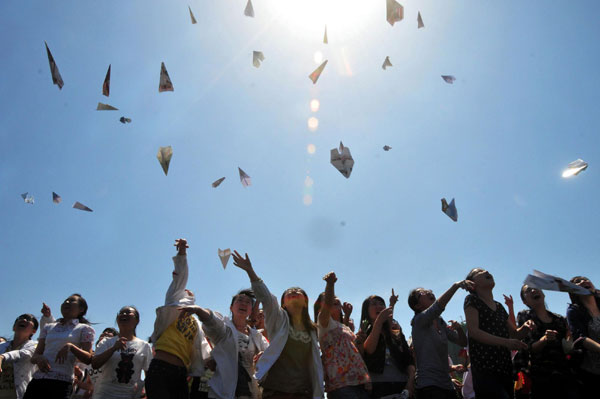 Students fly paper planes that carry their wishes for the upcoming National College Entrance Exam at a senior high school in Nanchong, Sichuan Province on May 14, 2012.