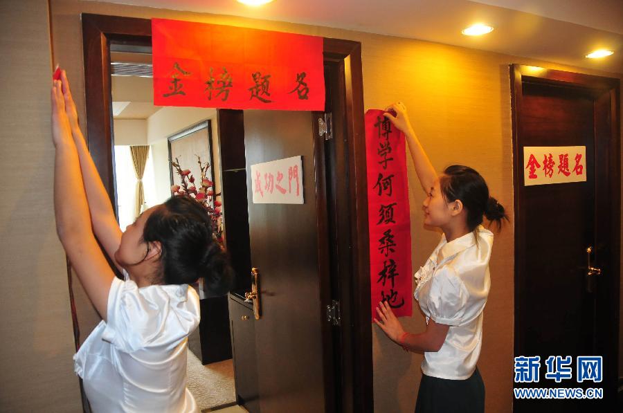 Hotel staff hangs banners outside the door of &apos;gaokao rooms&apos; to bless and encourage college entrance examinees to get good marks in Nanchong City, southwest China&apos;s Sichuan Province, May 28, 2012.