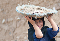 Child labor is common in Pakistan where families are forced to use their children for livelihood due to poverty. This child is helping her family on a construction site. Despite this suffering, she remains cheerful.