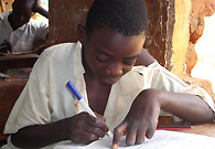 A boy from a poor family is doing his examination papers.