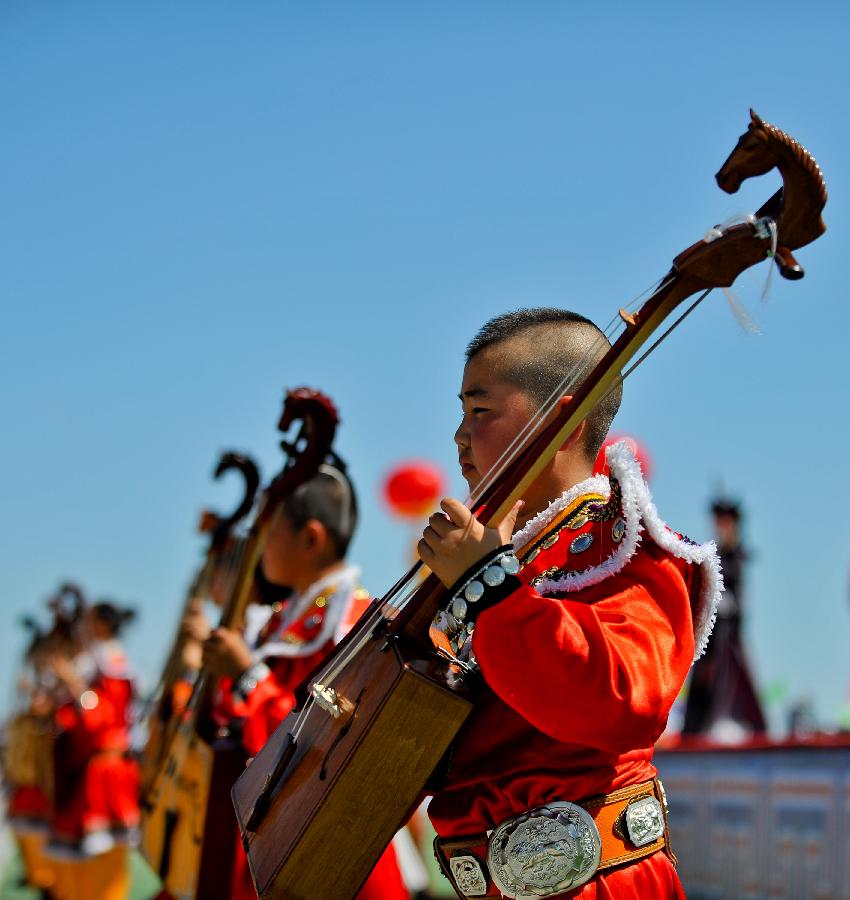 People perform during the opening of a Nadam fair in West Ujimqin Banner, north China's Inner Mongolia Autonomous Region, July 16, 2012.