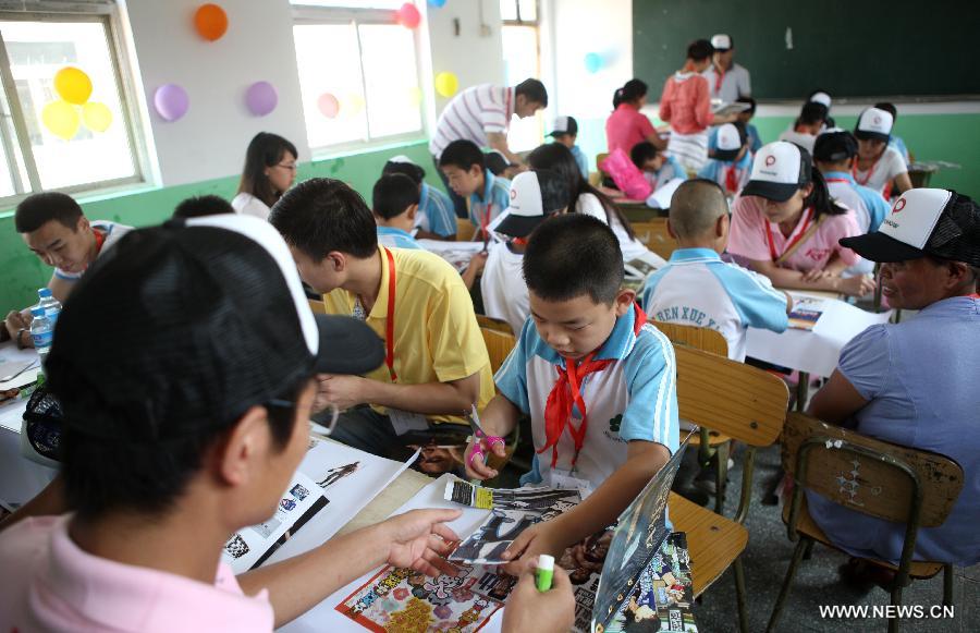Students cut pictures from magazines to patch big pictures about their dreams during a charitable activity in Shuren School, a school for the children of migrant workers, in Beijing, capital of China, Aug. 12, 2012. 