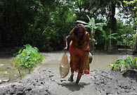 The woman walks back her house after begging. Her family members are waiting to see what she will bring back for them.