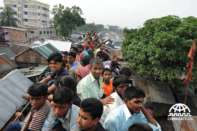 People are taking train in Bangladesh. It is so crowded so people are on the roof.