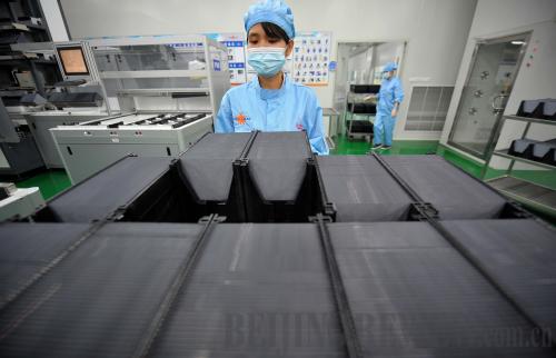 A worker at Yingli Solar in Hainan Province processes silicon chips on August 22.