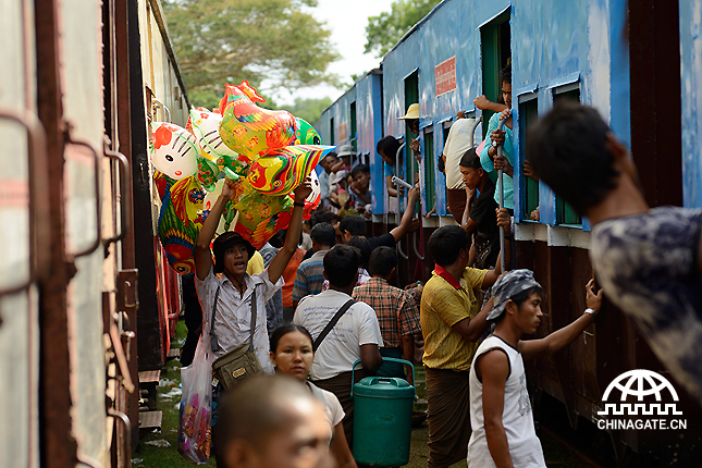 A man is selling toys between two trains during Taungpyone Pagoda Festival on the way to Mandalay. It was really dangerous for anybody to do so as the trains are coming in and going out all the time. 