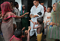 A Muslim devotee is giving alms to the poor.