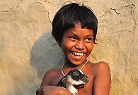 With a pet in her arms, a girl from a poverty-hit area is smiling.
