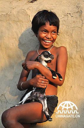 With a pet in her arms, a girl from a poverty-hit area is smiling.