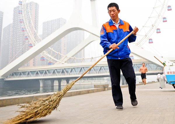 Xu Wenhua sweeps a street in Tianjin, Sept 22, 2012.