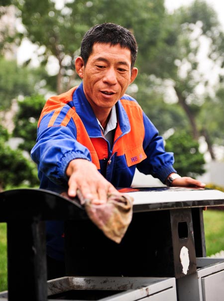 Xu Wenhua cleans a dustbin in Tianjin, Sept 22, 2012.