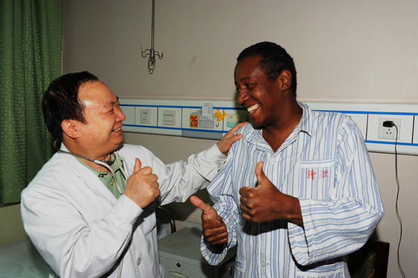 Zhuang Shihua talks to a Brazilian patient in a hospital in Urumqi, Xinjiang Uygur Autonomous Region, June 18, 2012. 