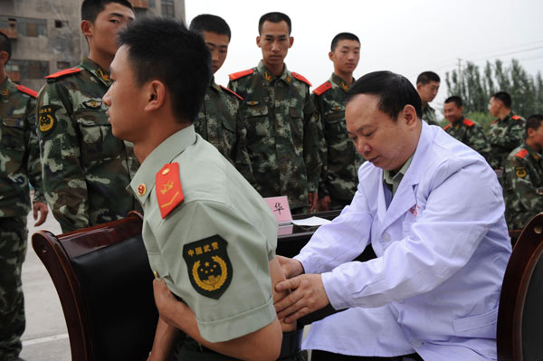 Zhuang Shihua examines a soldier in Urumqi, Xinjiang Uygur Autonomous Region, May 28, 2012.