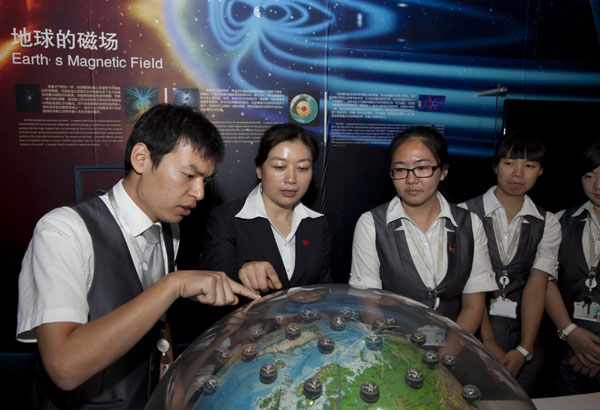 Qian Yan(2nd L), Party secretary of the China Science and Technology Museum, talks to instructors at the museum on Sept 13, 2012. 