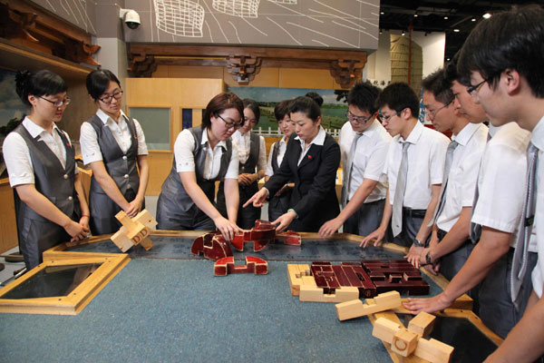 Qian Yan, Party secretary of the China Science and Technology Museum, studies with colleagues at the museum on Aug 17, 2012.