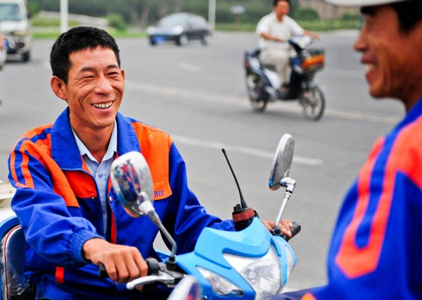 Xu Wenhua talks with a friend on his way to work in Tianjin, Sept 22, 2012. [Photo/Xinhua] 