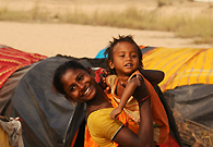 A young gypsy woman holds her son in front of her makeshift tent on the bank of Ajay River. General members of nomadic communities lack government amenities and their children seldom go to school. They make a living by doing odd jobs like snake charming or some form of petty business activities.