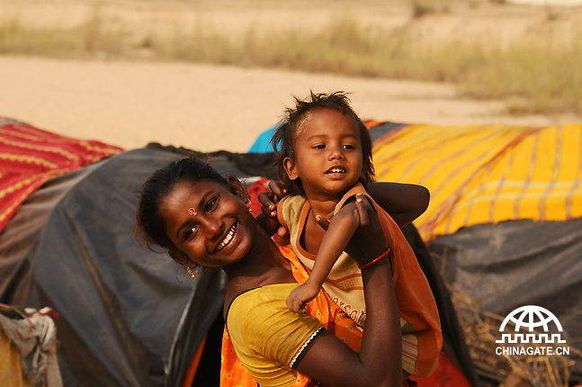 A young gypsy woman holds her son in front of her makeshift tent on the bank of Ajay River. General members of nomadic communities lack government amenities and their children seldom go to school. They make a living by doing odd jobs like snake charming or some form of petty business activities.