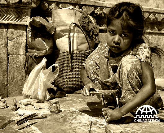 A girl is making abstract stone sculptures, to survive at this age of her life. The pain in her eyes can express the hardships of her childhood.