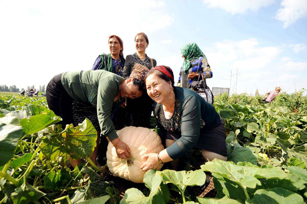 Women visit an agricultural technology model base in Yining County in Xinjiang Uygur Autonomous Region on July 15, 2012.