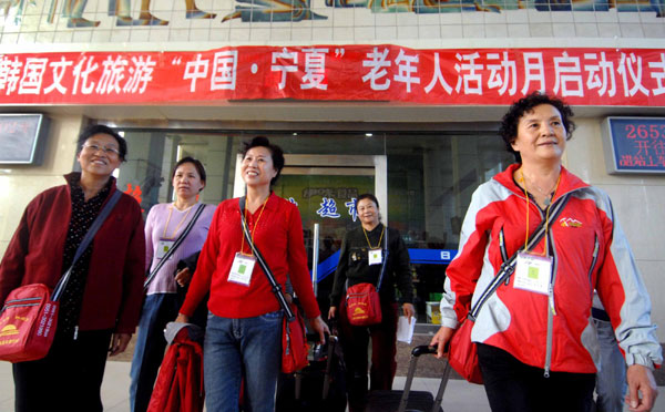 Tourists bound for South Korea prepare to get on a train in Yinchuan, Ningxia Hui Autonomous Region, on Oct 15, 2010. 