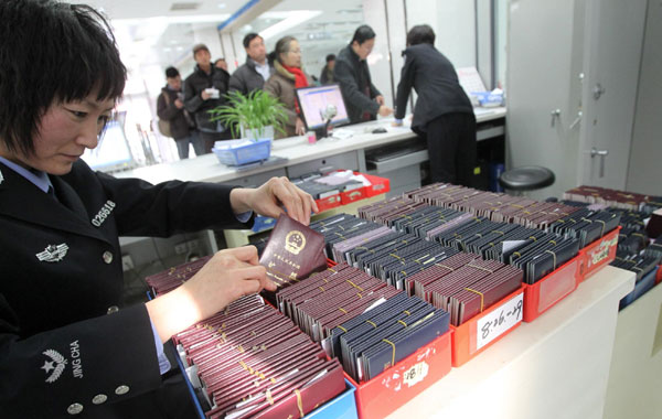 A policewoman looks through passports for applicants in Beijing, on Oct 19, 2012. 