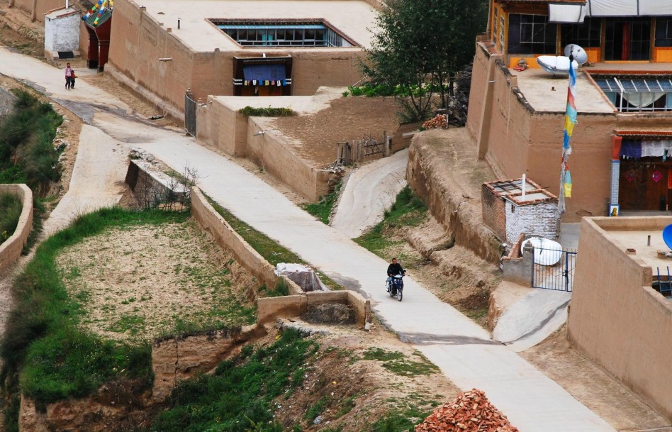 Nyima Tsering rides a motorcycle to visit famers in Jicang Village, Huangnan Tibet Autonomous Prefecture, Qinghai Province, Aug 22, 2012.