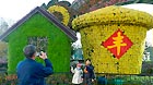 Visitors pose for photos in front of the flower decorations displayed on the street to greet the upcoming 18th National Congress of the Communist Party of China (CPC) in Beijing, capital of China, Oct. 30, 2012.