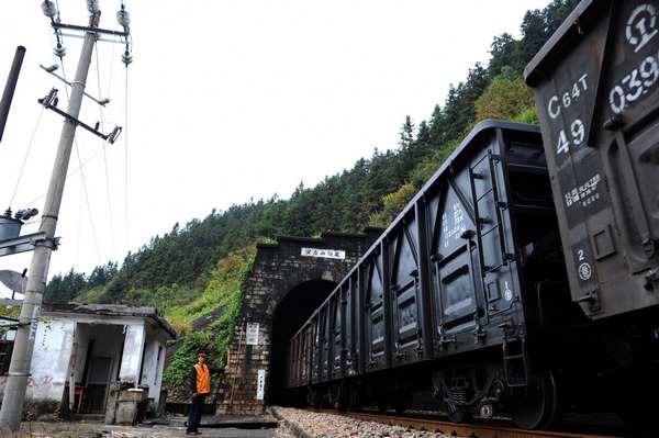 Li signals to a coming train by holding a yellow flag at the Huangtaishan tunnel of Wan-Gan railway which is located on remote mountains in Wannan region, east China's Anhui Province, Oct 30, 2012.