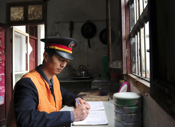 Li writes his patrol record at his office near the Huangtaishan tunnel in Qimen County, east China's Anhui Province, Oct 30, 2012.