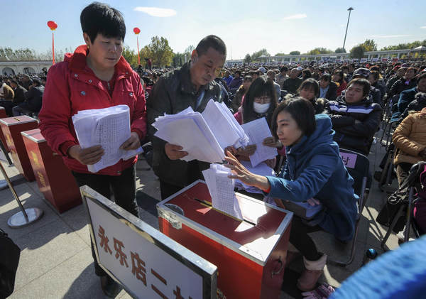 Villagers put their evaluation reports in a ballot box after the village party secretaries delivered their work report in Yongle County in Tongzhou District in Beijing, Oct 31, 2012.