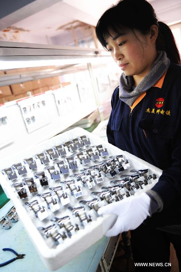 A staff member of a company presents galvanized products in Qingdao, east China's Shandong Province, Nov. 1, 2012. 