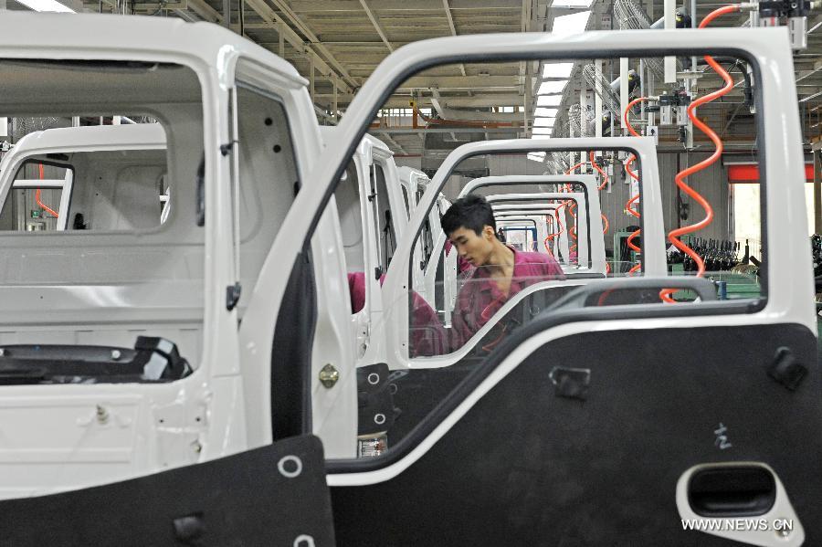 Workers assemble vehicles in Qingzhou, east China's Shandong Province, Aug. 21, 2012.