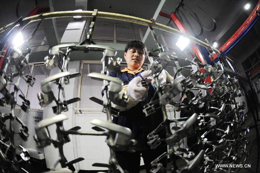 A worker of a company processes galvanized products in Qingdao, east China's Shandong Province, Nov. 1, 2012.