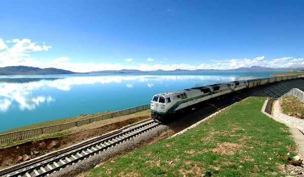 A train rolls along the Tsonag Lake in northern Tibet Autonomous Region on July 20, 2006.