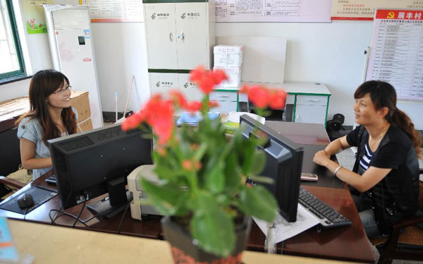 Zhong Yi (L) works at the one-stop service center in Zhanfeng Village of Jiashan County, east China&apos;s Zhejiang Province, June 29, 2012.