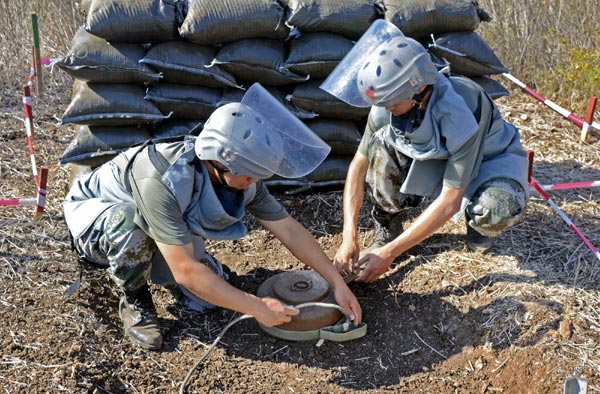 Cui Yongbiao and his fellow soldier, mine clearers of the 10th Chinese peacekeeping engineer battalion in Lebanon, remove an anti-tank mine at the Lebanon-Israel border on Aug 28, 2012.