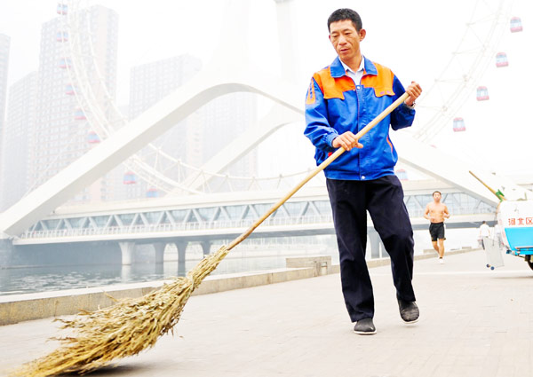 Xu Wenhua sweeps a street in Tianjin, Sept 22, 2012. 