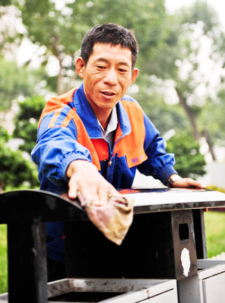 Xu Wenhua cleans a dustbin in Tianjin, Sept 22, 2012.