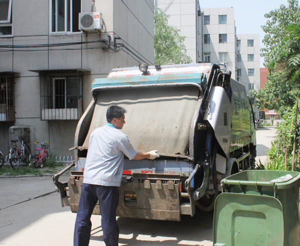 Ren Xiaoyun operates a garbage truck in Beijing on July 13, 2012.