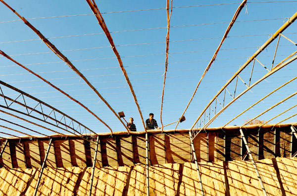 Villagers of Hougoumen Village build a 5th-generation new greenhouse in Shaanxi Province, Nov 5, 2012.