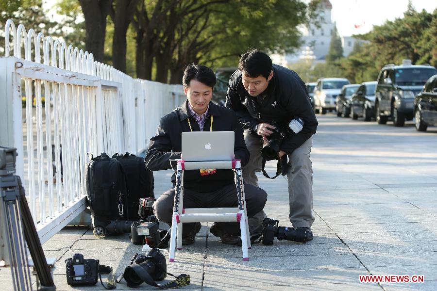 Xinhua photographers Xie Huanchi (L) and Wang Ye work during their coverage of the 18th National Congress of the Communist Party of China (CPC) at the Tian'anmen Square in Beijing, capital of China, Nov. 8, 2012.