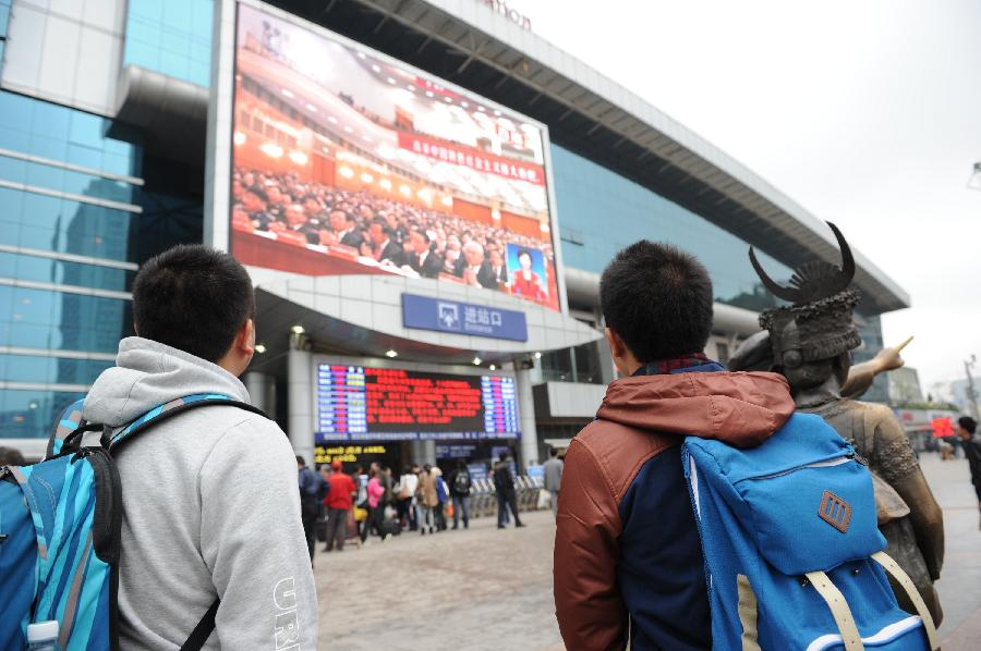 Passengers watch TV reporting the opening ceremony of the 18th National Congress of the Communist Party of China (CPC) at the railway station in Guiyang, capital of southwest China's Guizhou Province, Nov. 8, 2012.