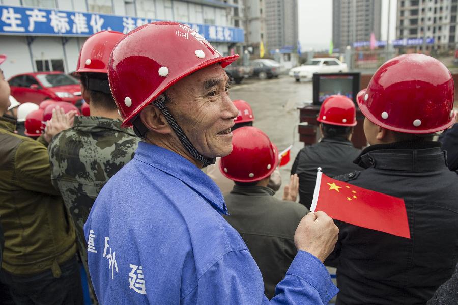 Construction workers watch TV reporting the opening ceremony of the 18th National Congress of the Communist Party of China (CPC) in southwest China's Chongqing, Nov. 8, 2012.