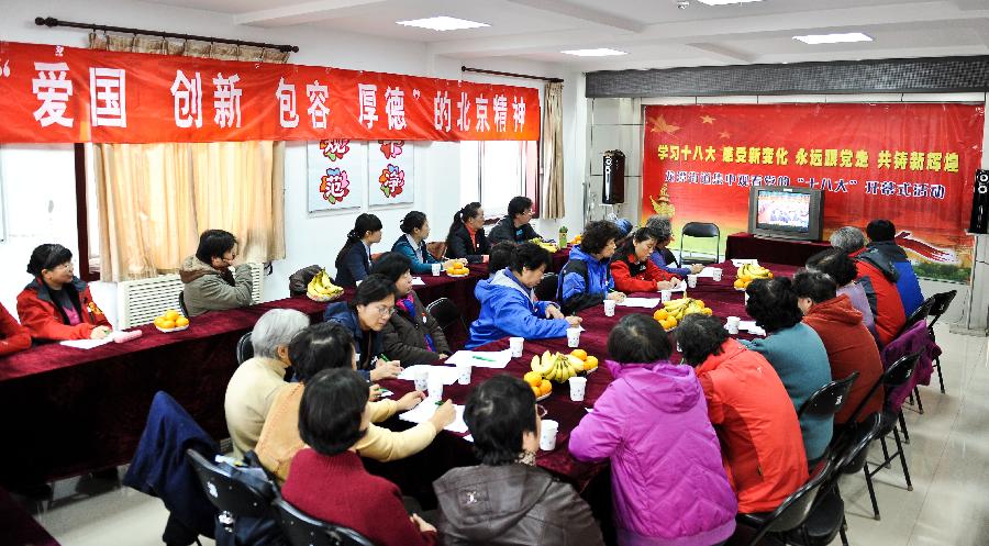 Local residents watch TV reporting the opening ceremony of the 18th National Congress of the Communist Party of China (CPC) in Beijing, capital of China, Nov. 8, 2012. 