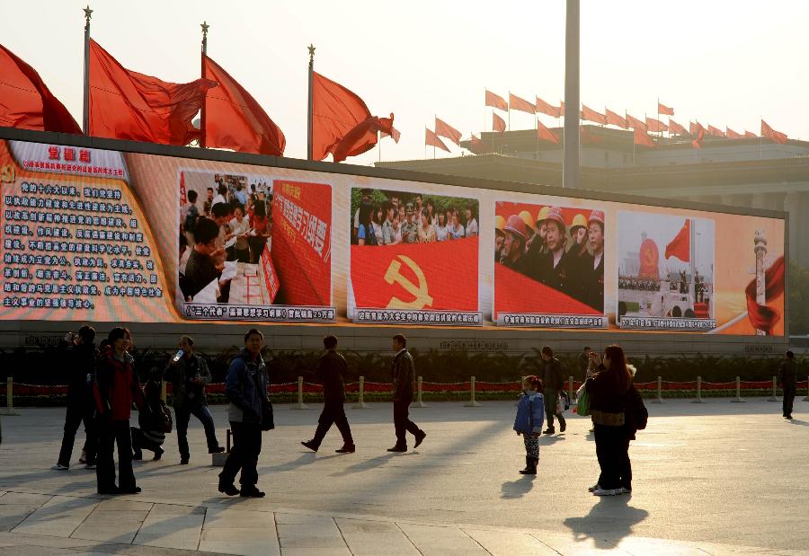 Visitors watch a large screen displaying achievements which China has gained under the leadership of the Communist Party of China (CPC) in the past decade, at the Tian'anmen Square in central Beijing, capital of China, Nov. 8, 2012.