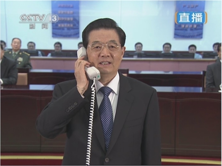 Chinese President Hu Jintao talks to the three Chinese astronauts who carried out scientific tests in Tiangong-1 lab module via video link at the Beijing Aerospace Control Center (BACC) in Beijing, Jun. 26, 2012. 