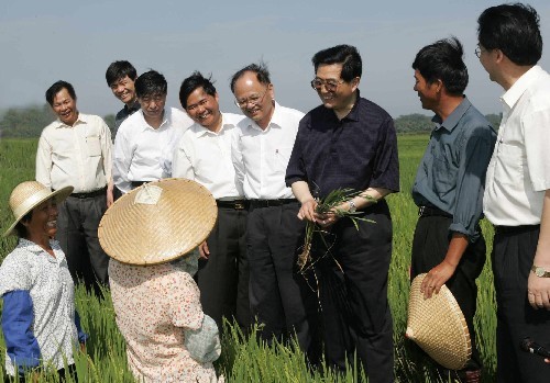 Chinese President Hu Jintao (3rd, R) talks with the local farmers in Jiaji Town of Qionghai City, Hainan Province during an inspection tour of Hainan, on Apr. 24, 2004.